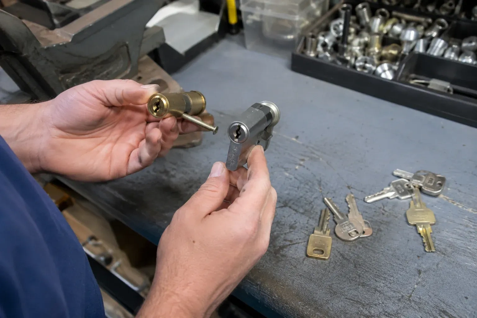 Hands comparing detached lock cylinders beside loose keys on a workbench. — Broken Key Extraction, Markham